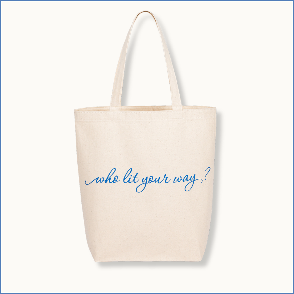 White tote bag that says "who lit your way?"