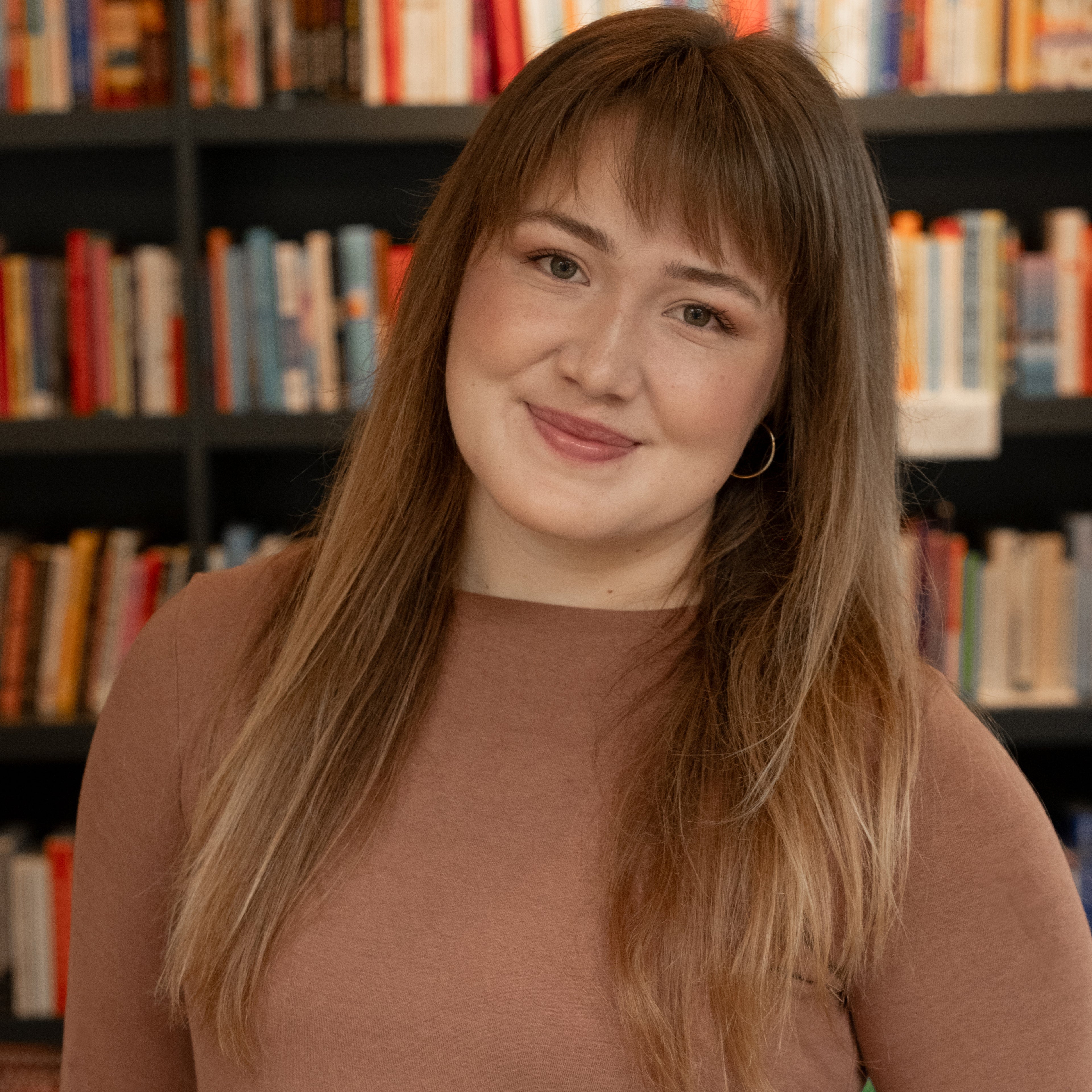 Kimi White in front of a wall of books