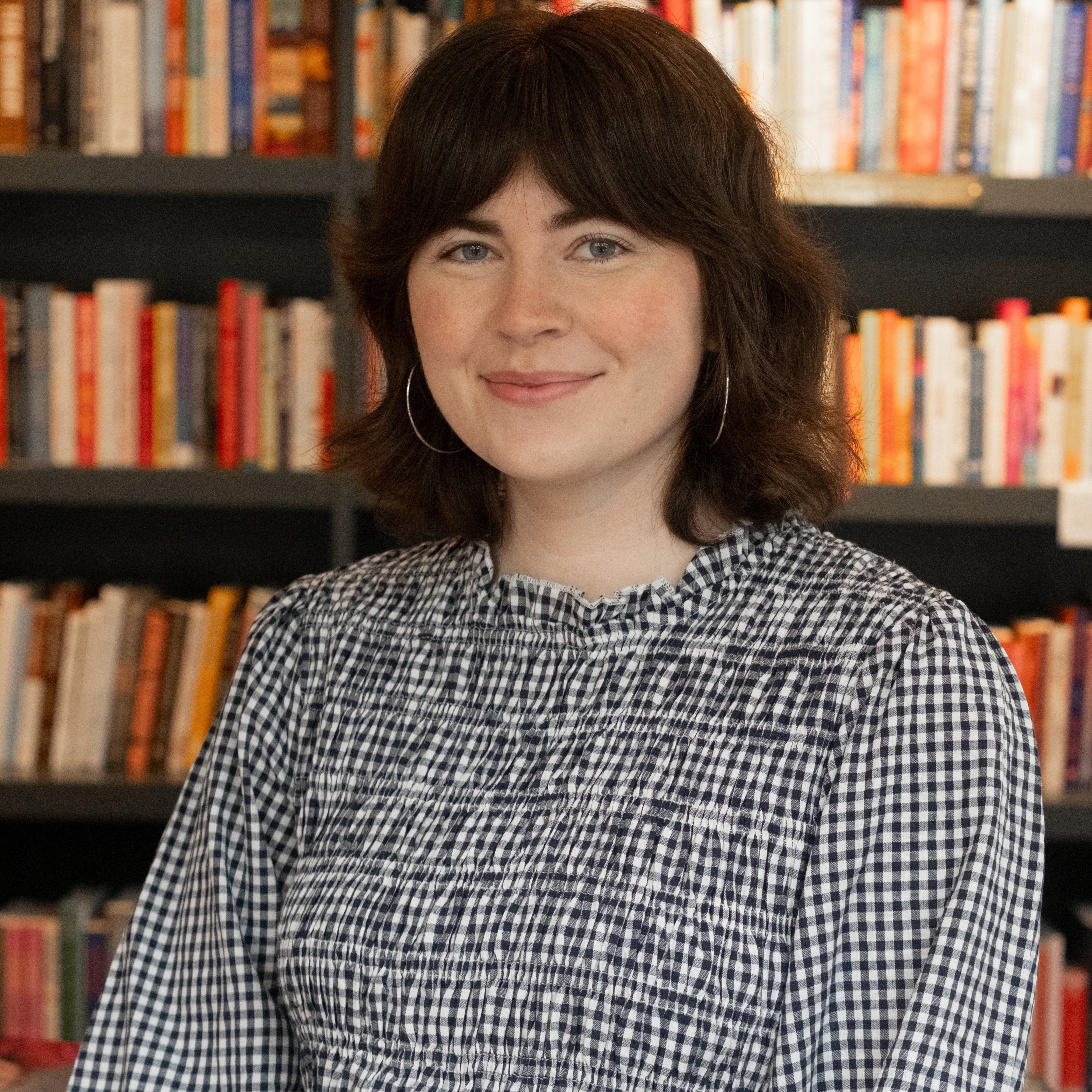 Mikayla Romeril in front of a row of books